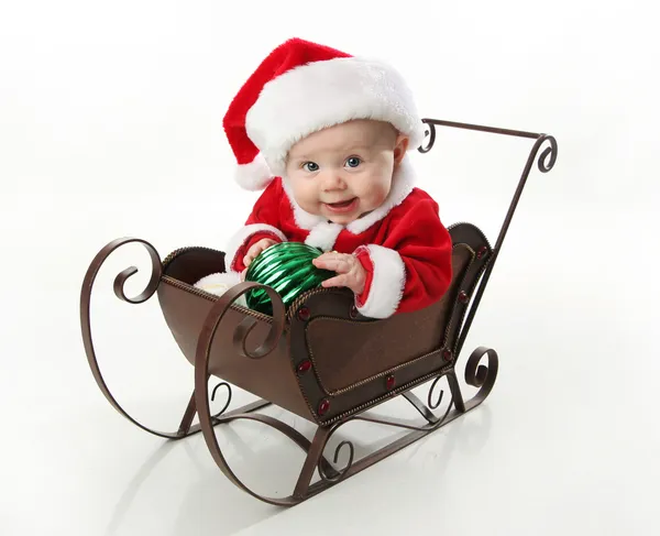 Santa μωρό κάθεται σε ένα έλκηθρο — Φωτογραφία Αρχείου