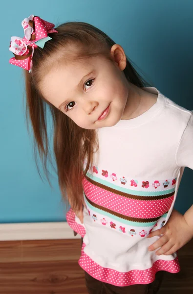 Malá holčička modelování vlasy luk a odpovídající košili — Stock fotografie