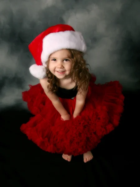 Κοριτσάκι που φοράει Χριστουγέννων santa καπέλο και κόκκινο pettiskirt — Φωτογραφία Αρχείου