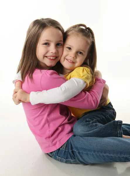 Δύο Χαριτωμένα Μικρά Αδελφές Που Αγκαλιάζονται Μεταξύ Τους Απομονωθεί Λευκό — Φωτογραφία Αρχείου