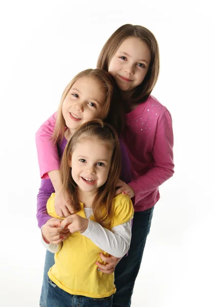 Três Jovens Irmãs Bonitos Abraçando Uns Aos Outros Isolado Branco — Fotografia de Stock