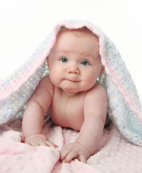 彼女の頭の上の手のかぎ針編み毛布とのピンクの毛布の上に彼女のおなかの上に横たわってかわいい女の子 — ストック写真