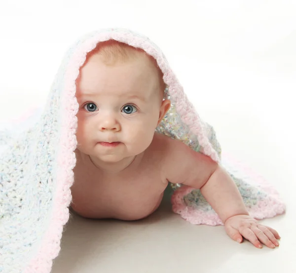 可爱的小宝贝女孩躺在她的肚子上用手钩织毯子在她的头 — 图库照片