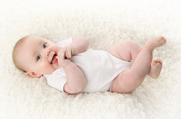 Baby lying on back smiling
