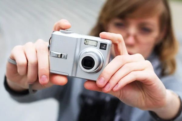Flickan håller kameran i händerna — Stockfoto