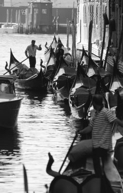 Gondoliers socialising in a canal in Venice, Italy. clipart