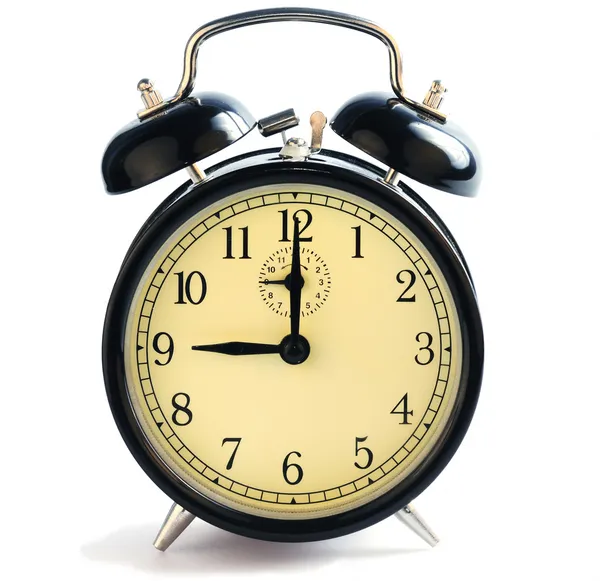 stock image An old-fashioned alarm clock showing nine o'clock.