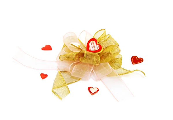 Gold bow with red hearts — Stock Photo, Image