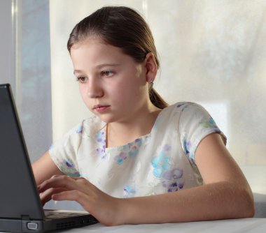 Dizüstü bilgisayar kullanan Genç Kız