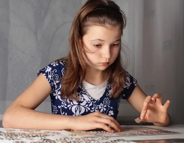 Teenage girl doing puzzle — Stock Photo, Image
