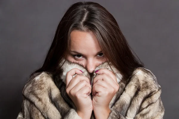 Girl hiding in fur coat — Stock Photo, Image