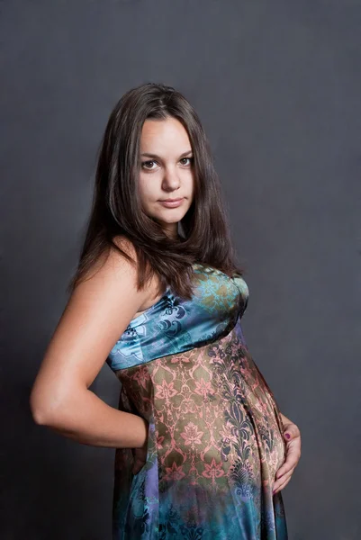 Jonge moeder in versicolor jurk — Stockfoto