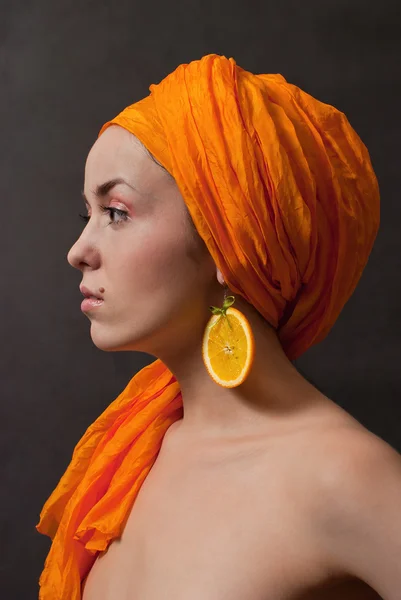 灰色背景的橙色头巾和水果耳环的美丽女孩 — 图库照片
