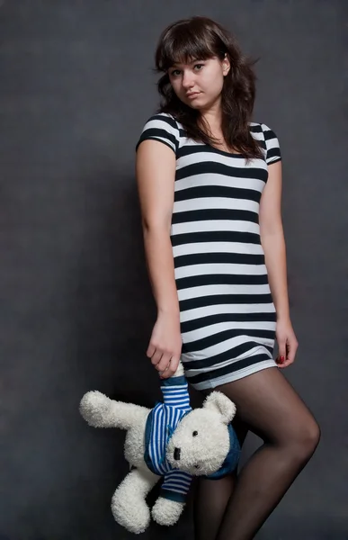 Девушка Красавица Игрушечным Медведем Полосатом Платье Сером Фоне — стоковое фото