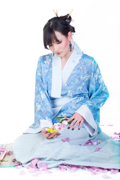 Geisha in kimono blu con ramoscello di sakura — Foto Stock
