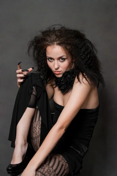 美年轻女巫用黑色钉选址上灰色背景 — 图库照片