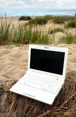 Kumsalda beyaz küçük laptop