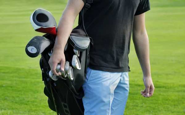Male golfer carrying clubs, close-up — Stock Photo, Image