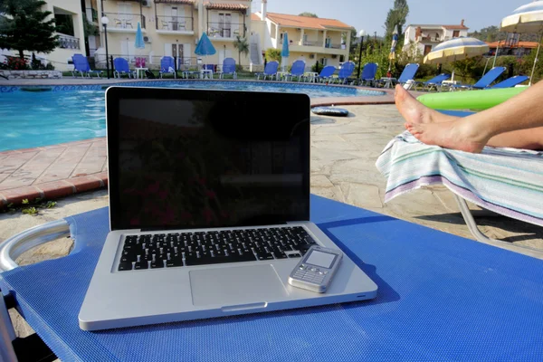 stock image Laptop and a mobil phone beside a pool