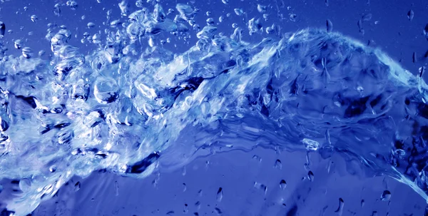 Макросъемка чистой голубой воды на синем фоне — стоковое фото