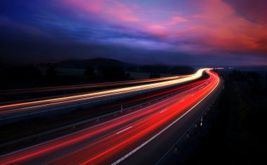 Cars at night with motion blur. clipart