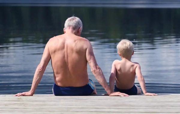 Grandfather and Grandson sitting on a footbridge — Stock Photo, Image
