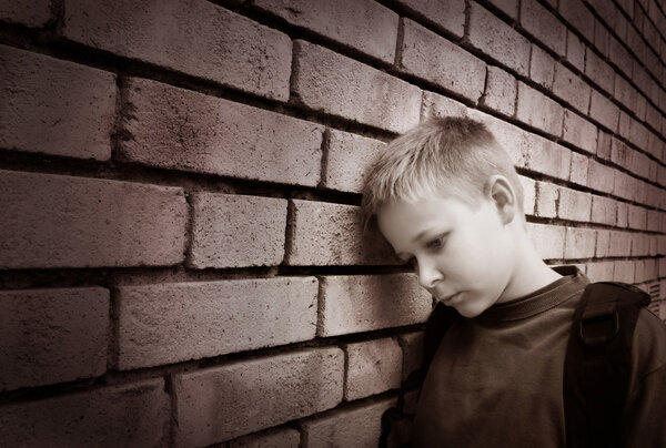 Boy leaning against a wall
