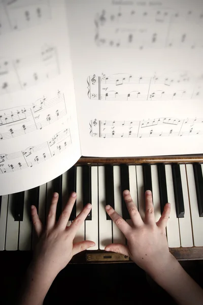 Les mains d'un enfant jouant sur un vieux piano — Photo