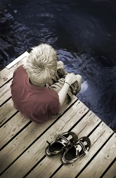 Ragazzo seduto su un ponte pedonale — Foto Stock