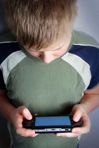 Boys hand playing portable video game — Stock Photo, Image