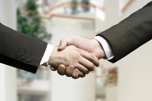 Business hand shake and a office in background — Stock Photo, Image
