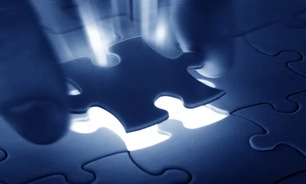 Hands placing last piece of a Puzzle — Stock Photo, Image