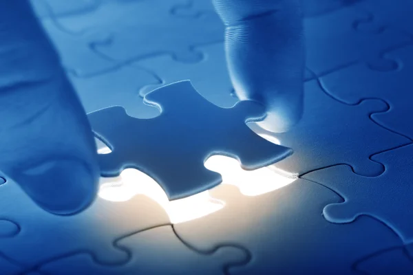 Hands placing last piece of a Puzzle — Stock Photo, Image