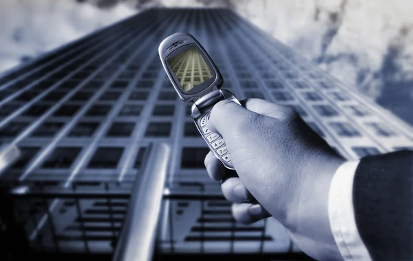 Businessman photographing a skyscraper with a cellphone — Stock Photo, Image