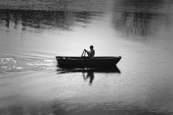 En man i hans roddbåt, lugna sommarmorgon — Stockfoto
