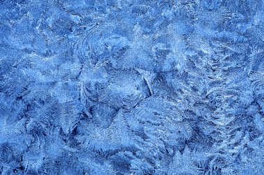 Frost patterns on window glass in winter clipart