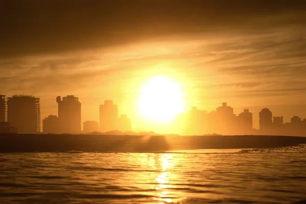 stock image Gold sun disc on sand beach with blue sea.