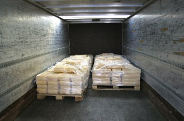 Manufactured cheese on pallets in back of truck clipart