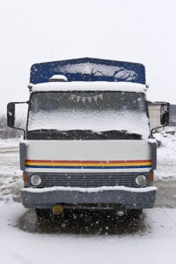 An old truck parked in the snow clipart