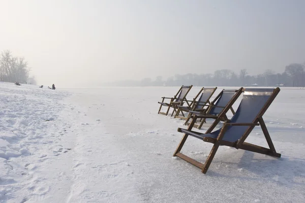 Liegestühle am zugefrorenen See — Stockfoto