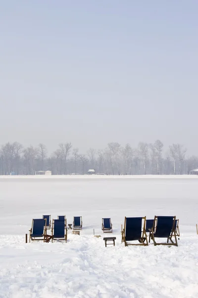 Liegestühle auf einem zugefrorenen See — Stockfoto