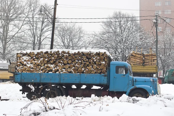 Παλιό φορτηγό με καυσόξυλα στο χιόνι — Φωτογραφία Αρχείου