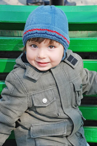 Boy on a green bench — Stock Photo, Image