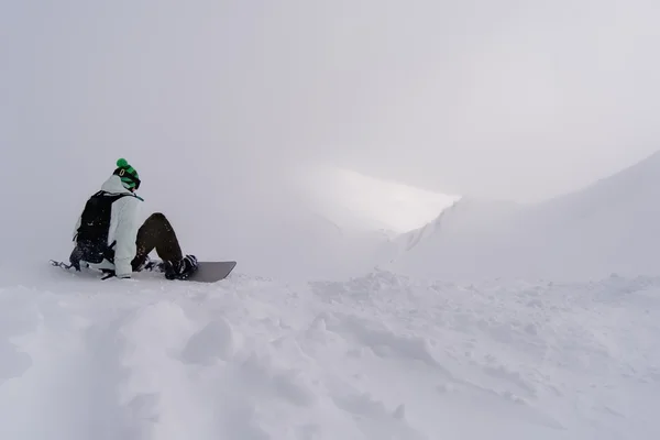 Snowboarder Assis Sur Neige Dans Les Montagnes Brumeuses Avant Descente — Photo