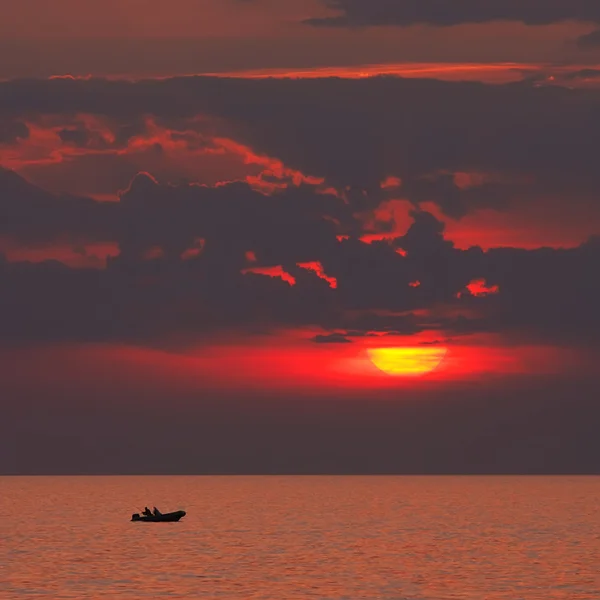 Gün batımında tekne içinde yalnız balıkçı