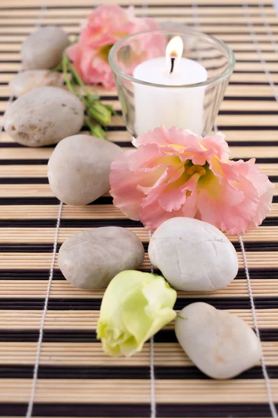 Stones with candle on bamboo mate — Stock Photo, Image