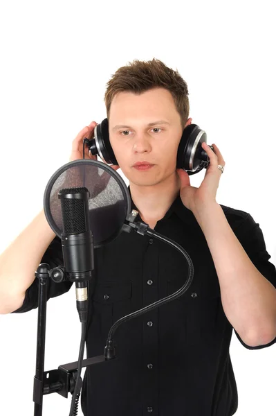 Mladý muž s mikrofonem na bílém pozadí — Stock fotografie