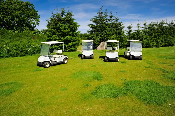 Quatro eco-transportadores em campo de golfe — Fotografia de Stock