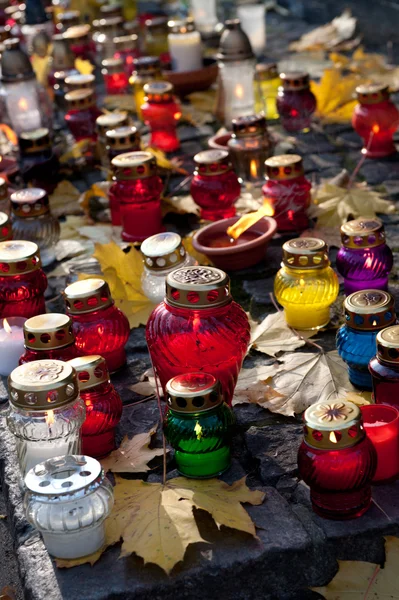 Kleurrijke kaarsen op begraafplaats — Stockfoto