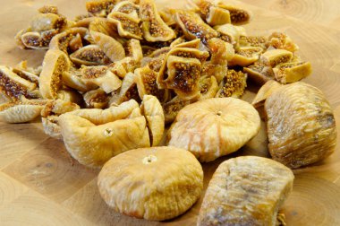 Dry figs on wooden worktop, cut and ready to cook clipart